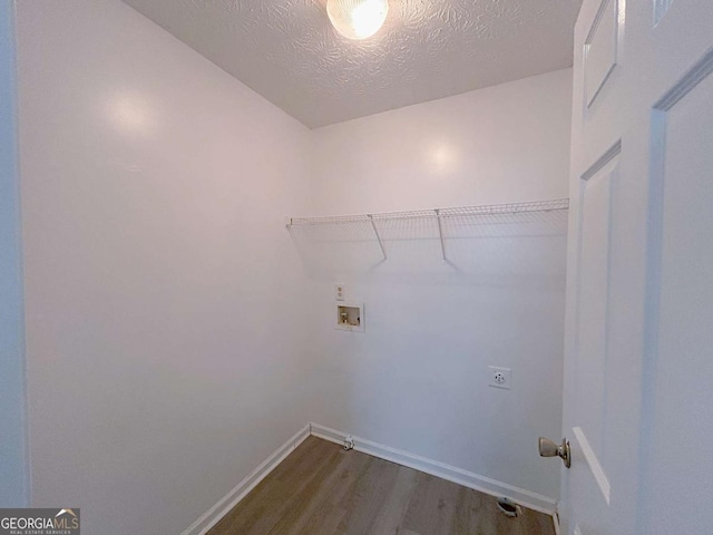 laundry area with electric dryer hookup, washer hookup, a textured ceiling, dark wood finished floors, and laundry area