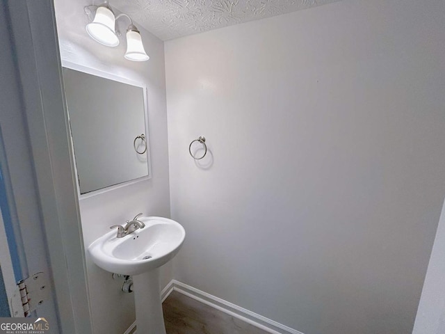 bathroom with a textured ceiling and baseboards