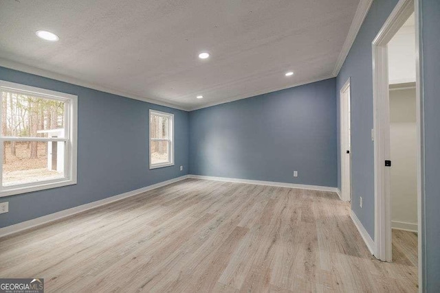 empty room featuring ornamental molding and light hardwood / wood-style floors