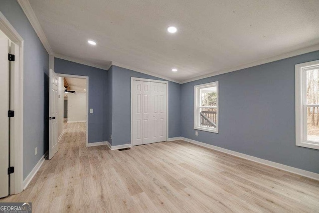 unfurnished bedroom with vaulted ceiling, light hardwood / wood-style floors, and a closet