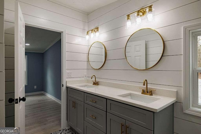 bathroom with crown molding, vanity, wood-type flooring, and wood walls