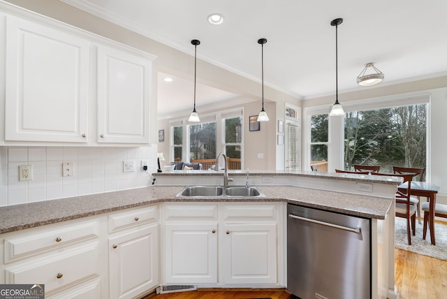 kitchen featuring sink, crown molding, dishwasher, white cabinetry, and kitchen peninsula