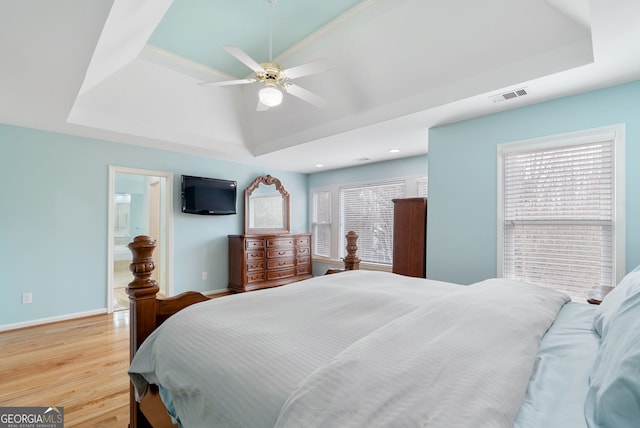 bedroom with a raised ceiling, ceiling fan, lofted ceiling, and light wood-type flooring