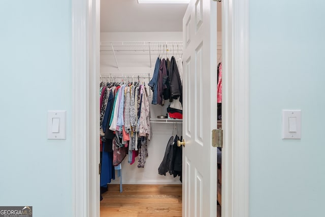 walk in closet with hardwood / wood-style floors