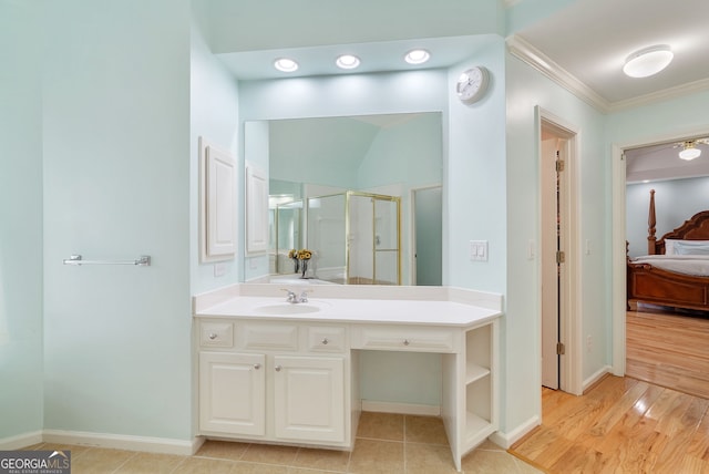 bathroom featuring crown molding, vanity, a shower with door, and hardwood / wood-style flooring