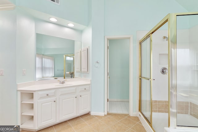 bathroom with an enclosed shower, vanity, and tile patterned floors