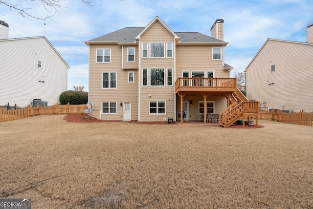 back of house with a wooden deck and a yard