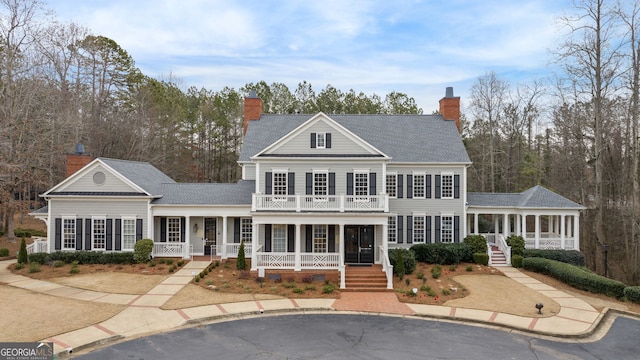 view of front of house with a porch, a balcony, and a sunroom