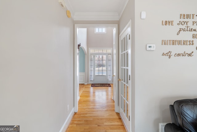 corridor featuring french doors, crown molding, and light hardwood / wood-style flooring