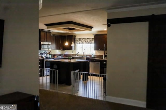 kitchen featuring sink, a breakfast bar, appliances with stainless steel finishes, a center island, and dark brown cabinetry