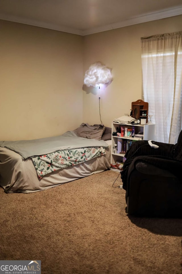 bedroom with ornamental molding and carpet