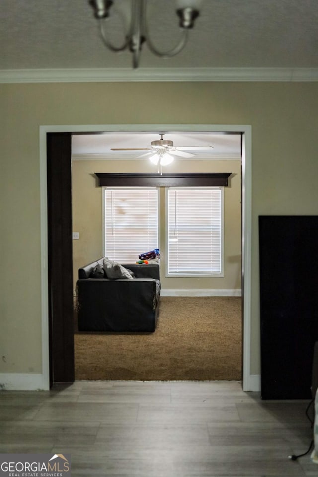 living room with ceiling fan and ornamental molding