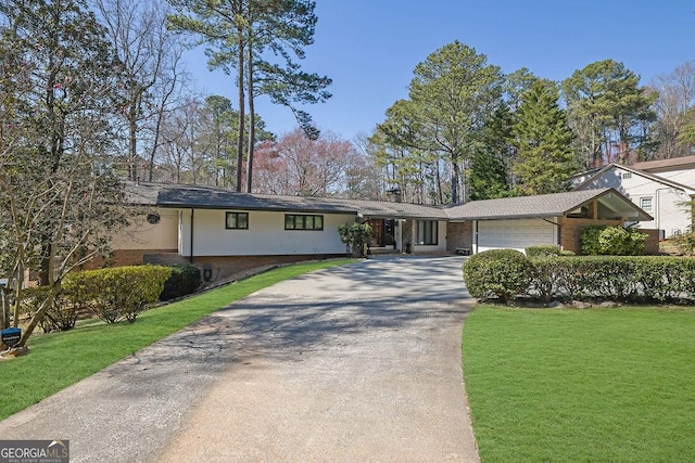 view of front of house featuring a garage, brick siding, driveway, and a front yard