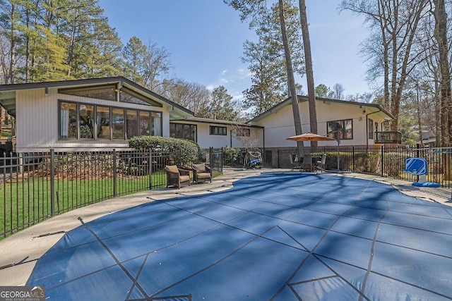 back of property featuring fence and a fenced in pool