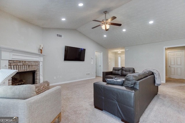 carpeted living room with a brick fireplace, a textured ceiling, vaulted ceiling, and ceiling fan