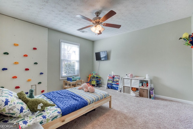 carpeted bedroom with a textured ceiling and ceiling fan