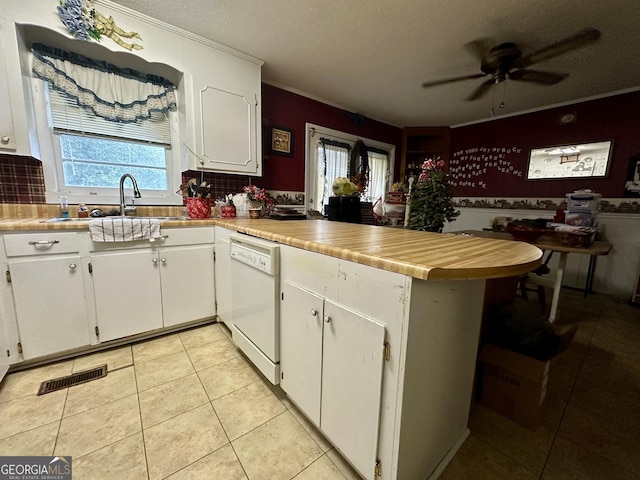 kitchen featuring sink, white cabinetry, light tile patterned floors, dishwasher, and kitchen peninsula