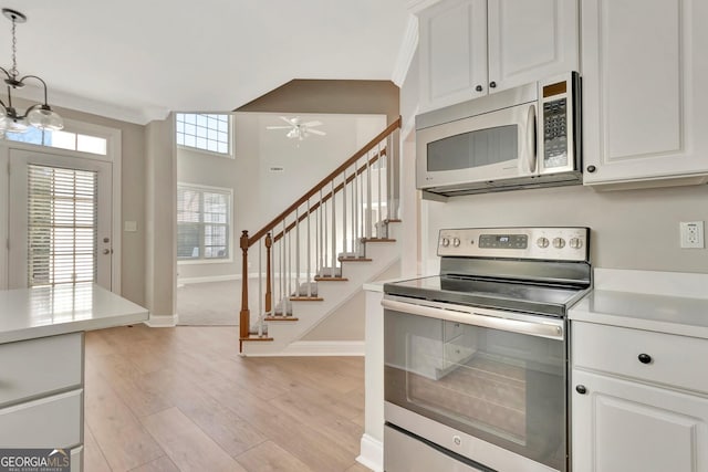 kitchen featuring pendant lighting, white cabinets, ceiling fan, stainless steel appliances, and light wood-type flooring