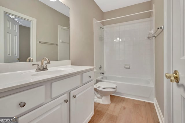 full bathroom featuring vanity, hardwood / wood-style flooring, toilet, and tiled shower / bath