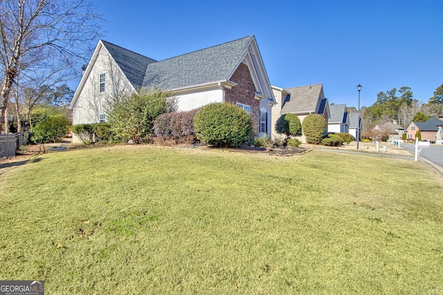 view of side of home with a yard