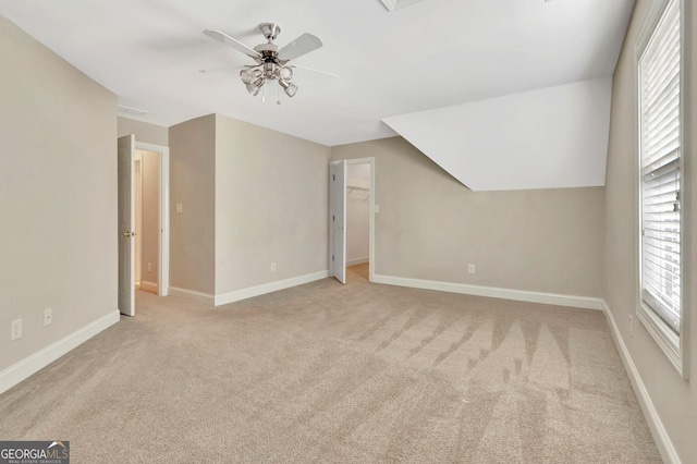 bonus room with lofted ceiling, light carpet, and ceiling fan