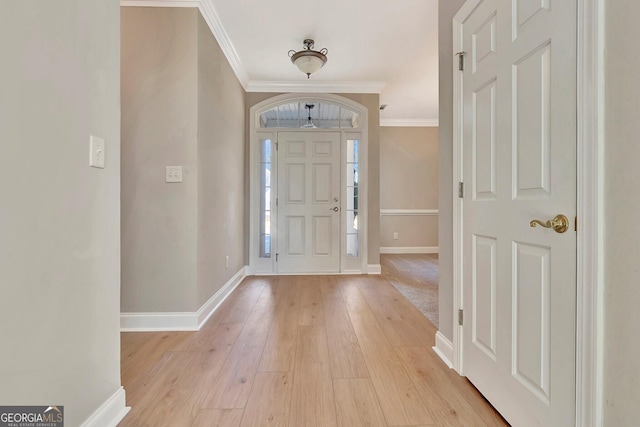 foyer entrance featuring crown molding and light hardwood / wood-style flooring