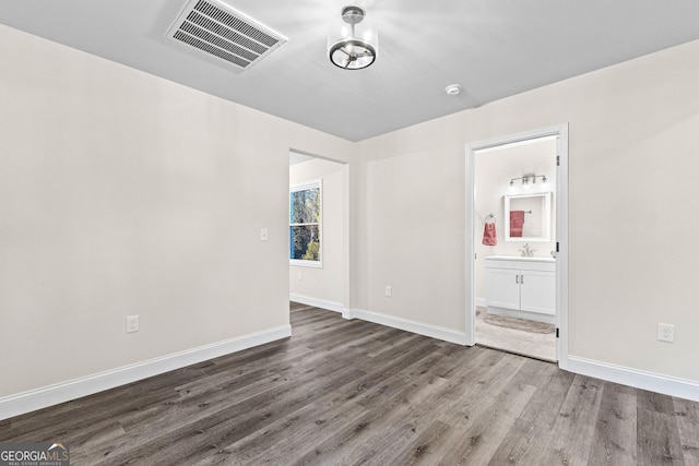 unfurnished room featuring wood-type flooring and sink