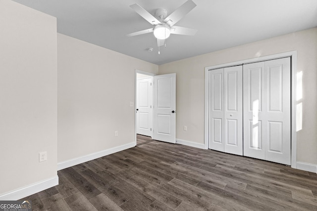 unfurnished bedroom with dark hardwood / wood-style flooring, ceiling fan, and a closet