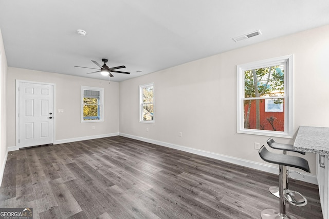 interior space with dark wood-type flooring and ceiling fan