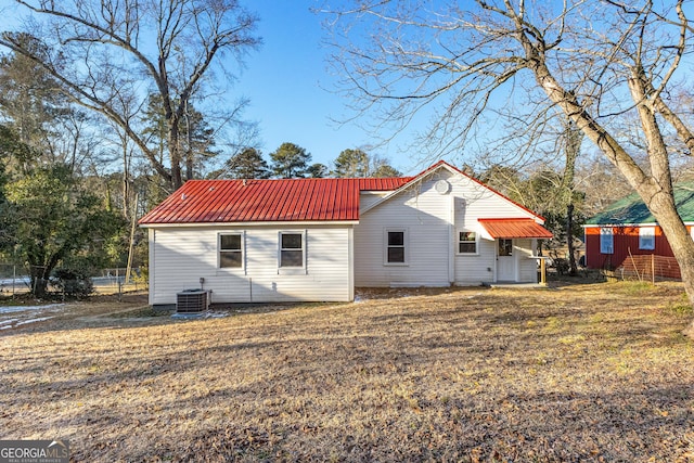 back of house with a yard and central AC