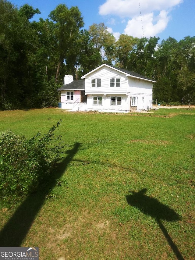 back of property featuring a lawn