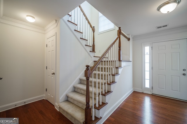 entrance foyer featuring ornamental molding and dark hardwood / wood-style floors