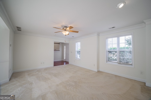 empty room featuring light carpet, crown molding, and ceiling fan