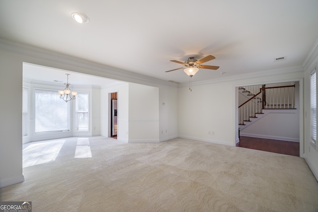 unfurnished living room featuring ceiling fan with notable chandelier, ornamental molding, and carpet