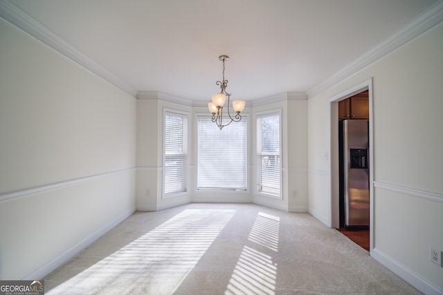 unfurnished dining area with a notable chandelier, light colored carpet, ornamental molding, and a healthy amount of sunlight