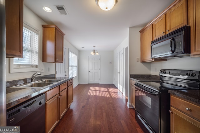 kitchen featuring pendant lighting, dark hardwood / wood-style floors, sink, and black appliances