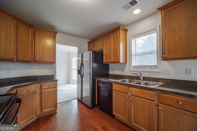 kitchen with sink, stainless steel fridge, range with electric cooktop, black dishwasher, and dark hardwood / wood-style flooring