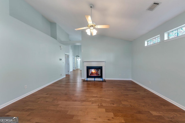 unfurnished living room featuring a multi sided fireplace, vaulted ceiling, dark wood-type flooring, and ceiling fan