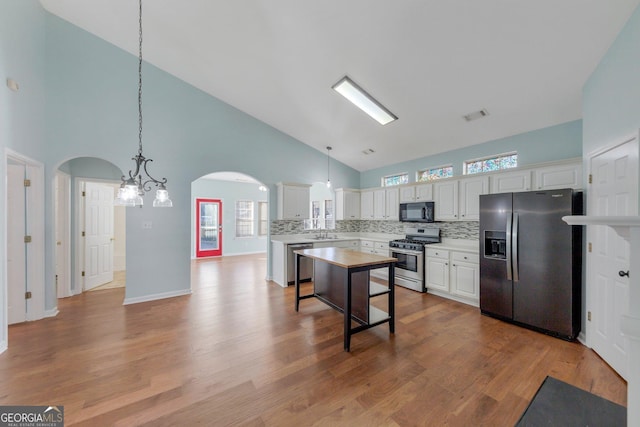 kitchen with white cabinetry, stainless steel appliances, and hanging light fixtures