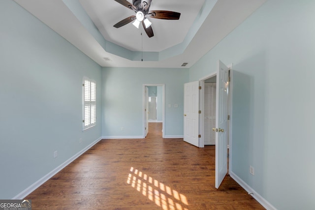 spare room featuring hardwood / wood-style flooring, ceiling fan, and a tray ceiling