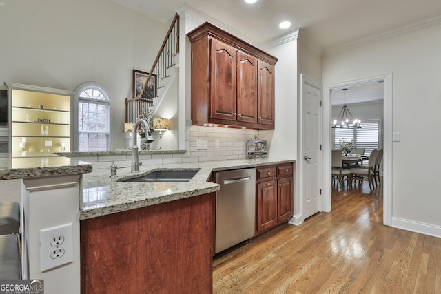 kitchen with sink, crown molding, dishwasher, tasteful backsplash, and light stone countertops