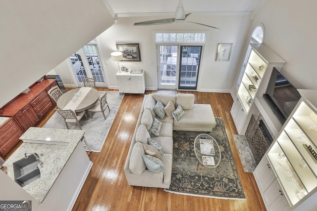 living room with hardwood / wood-style flooring, ornamental molding, and ceiling fan