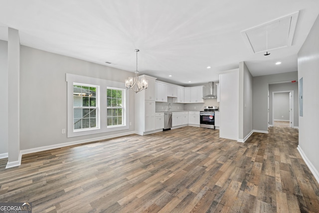 unfurnished living room with a notable chandelier, sink, and dark hardwood / wood-style floors