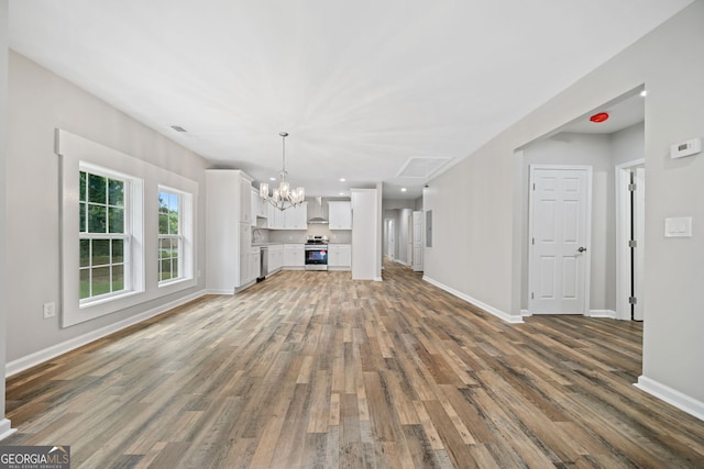 unfurnished living room featuring dark wood-type flooring and an inviting chandelier