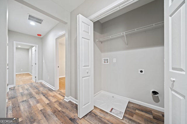 clothes washing area with hookup for a washing machine, electric dryer hookup, and hardwood / wood-style floors