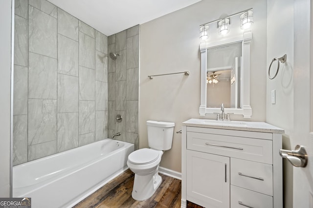 full bathroom featuring vanity, tiled shower / bath combo, wood-type flooring, and toilet