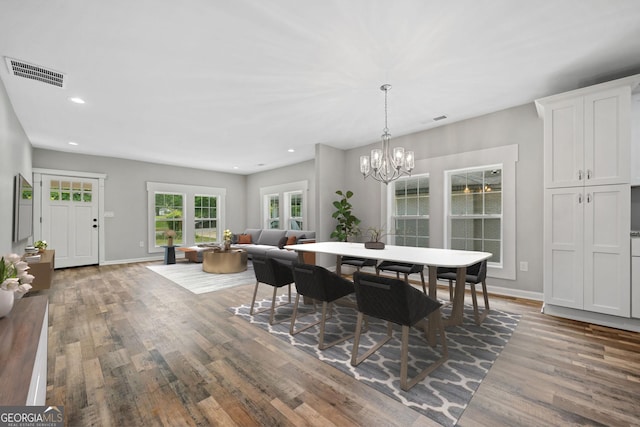 dining space with dark hardwood / wood-style flooring and a notable chandelier