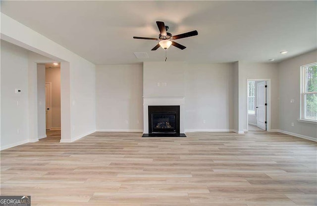 unfurnished living room featuring ceiling fan and light hardwood / wood-style flooring