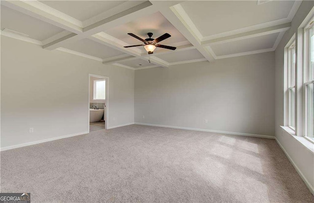 empty room with coffered ceiling, beam ceiling, and light carpet