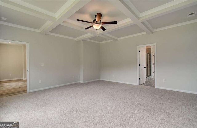 carpeted empty room featuring coffered ceiling, ceiling fan, and beamed ceiling